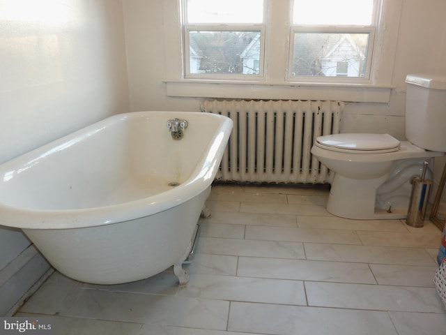 bathroom with a bathtub, tile flooring, toilet, and radiator heating unit