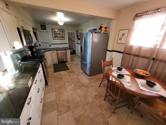 kitchen with white cabinetry, appliances with stainless steel finishes, light tile floors, and sink