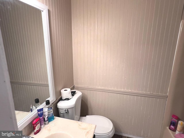 bathroom with toilet and wooden walls