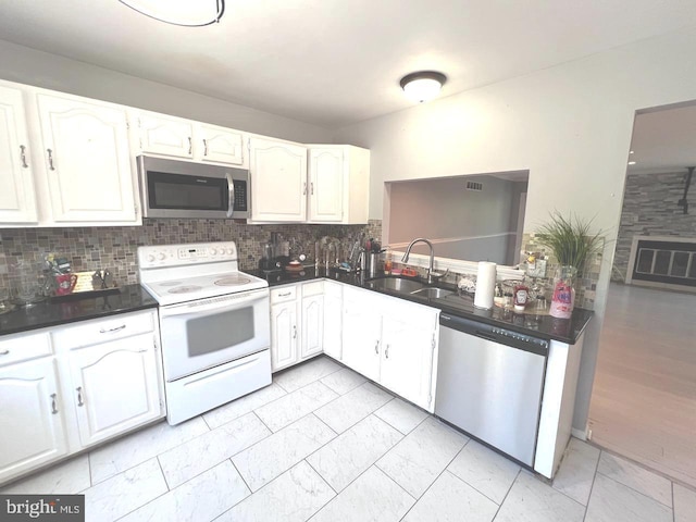 kitchen featuring tasteful backsplash, sink, white cabinets, and stainless steel appliances