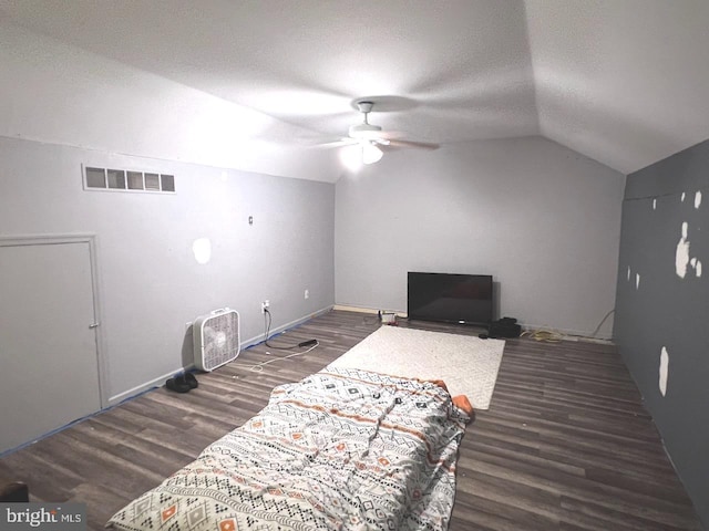 living room featuring a textured ceiling, ceiling fan, dark wood-type flooring, and vaulted ceiling