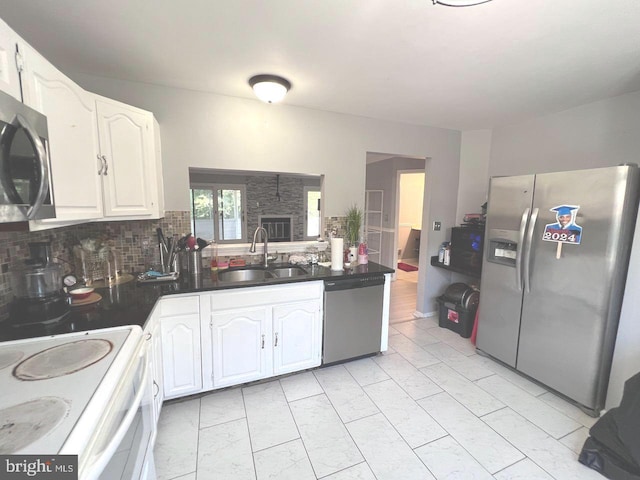 kitchen featuring appliances with stainless steel finishes, white cabinetry, and sink