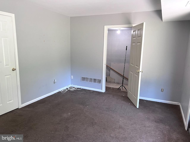 unfurnished bedroom featuring dark carpet