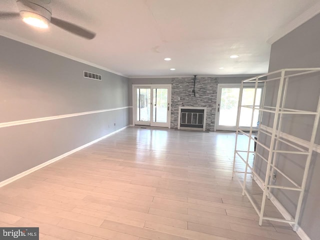 unfurnished living room featuring plenty of natural light, ceiling fan, crown molding, and light hardwood / wood-style flooring