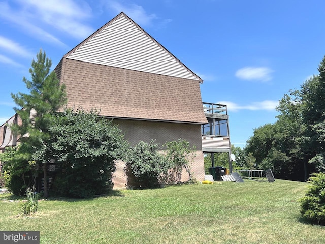 view of side of home with a balcony and a lawn