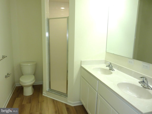 bathroom with dual sinks, oversized vanity, toilet, wood-type flooring, and walk in shower