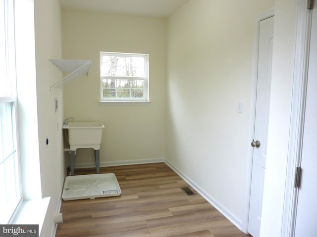 clothes washing area featuring light hardwood / wood-style floors