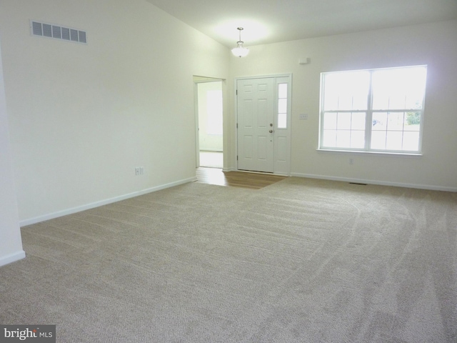 carpeted spare room with high vaulted ceiling