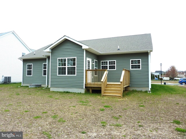 back of property featuring a wooden deck, central AC, and a lawn