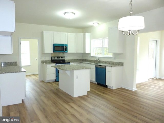 kitchen with a kitchen island, decorative light fixtures, white cabinetry, and stainless steel appliances