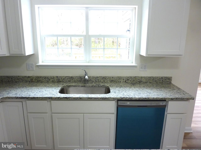 kitchen with stainless steel dishwasher, sink, light stone counters, and white cabinets