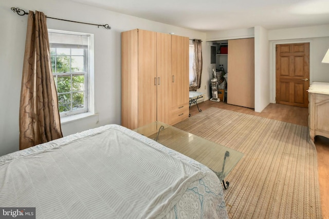 bedroom with a closet and light hardwood / wood-style flooring