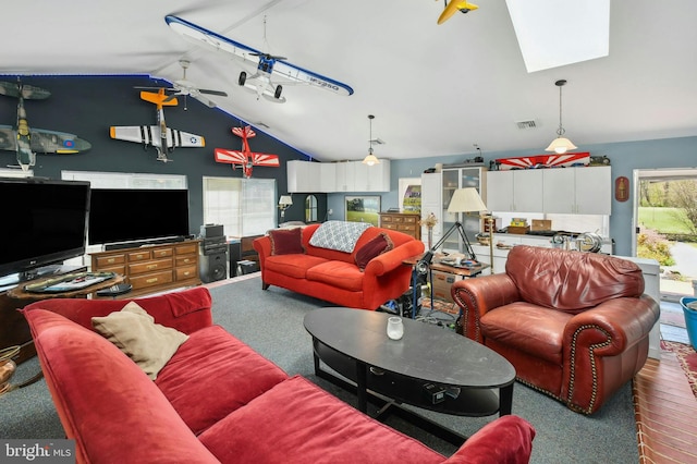 living room with a skylight, high vaulted ceiling, ceiling fan, and carpet flooring