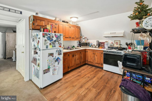 kitchen featuring sink, white appliances, hardwood / wood-style flooring, and custom range hood