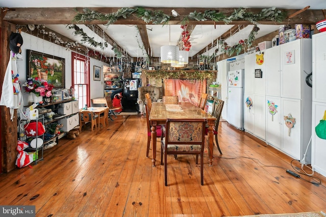 dining room with hardwood / wood-style floors and beam ceiling