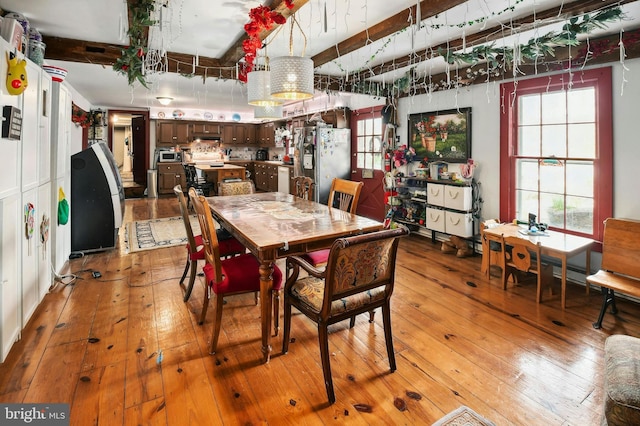 dining area featuring beam ceiling and light hardwood / wood-style floors