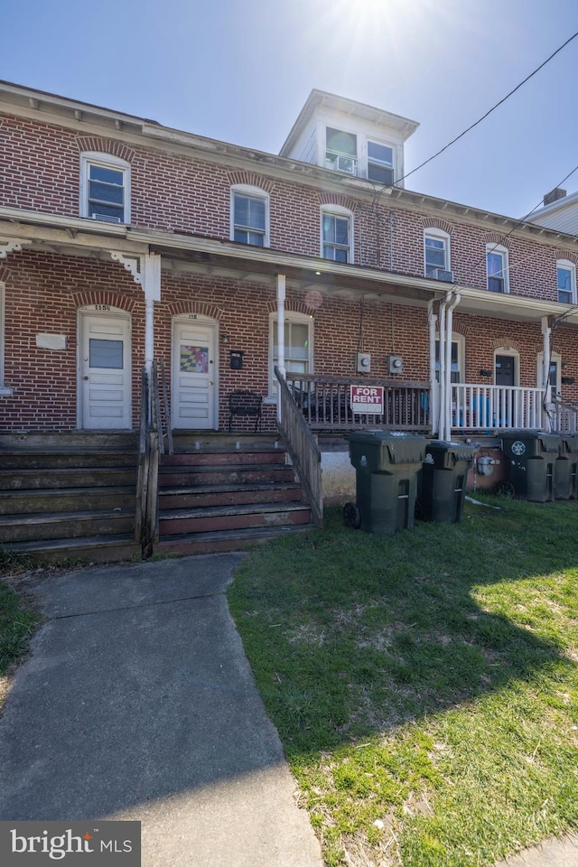 multi unit property with covered porch and a front yard