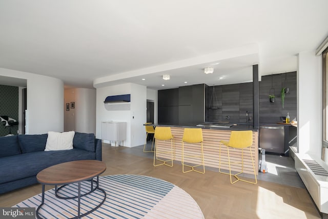 living room featuring sink, radiator, and light parquet flooring