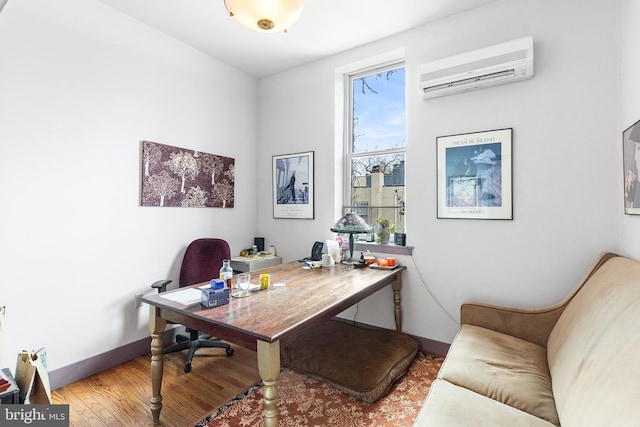 office area featuring a healthy amount of sunlight, wood-type flooring, and a wall unit AC