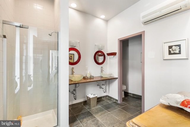 bathroom featuring sink, tile flooring, a wall mounted air conditioner, toilet, and a shower with shower door