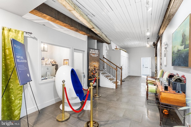 hallway featuring wood ceiling, beam ceiling, and dark tile flooring