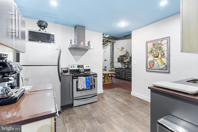 kitchen featuring wall chimney exhaust hood, dark hardwood / wood-style flooring, and stainless steel appliances