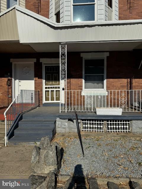 view of exterior entry featuring covered porch