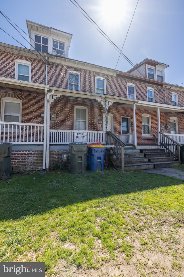 view of property featuring a front lawn and a porch