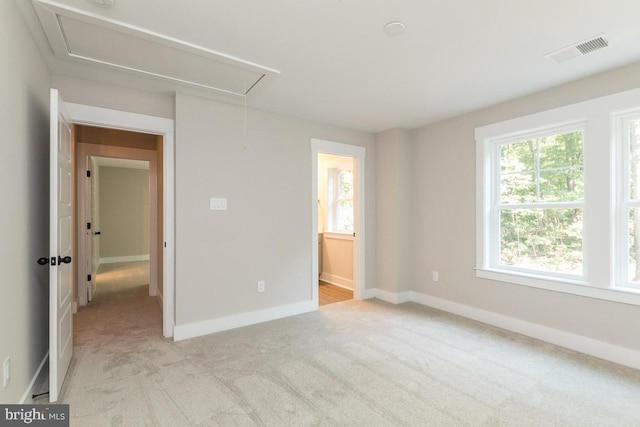 unfurnished bedroom featuring light carpet and ensuite bath