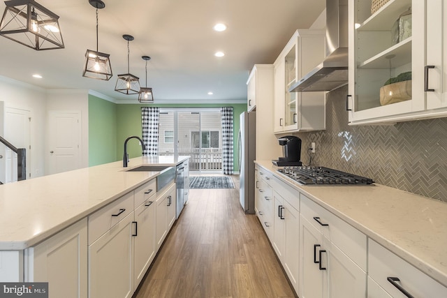 kitchen featuring white cabinets, crown molding, dark hardwood / wood-style floors, stainless steel appliances, and wall chimney exhaust hood