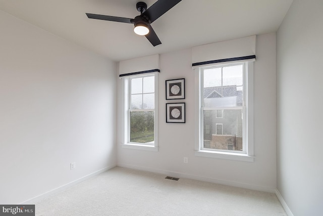 carpeted spare room featuring ceiling fan