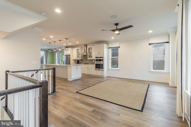 living room featuring sink, ceiling fan, and light hardwood / wood-style flooring