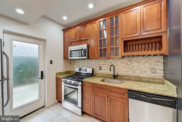 kitchen featuring light tile flooring, sink, stainless steel appliances, and a wealth of natural light