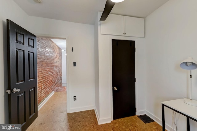 entrance foyer featuring brick wall