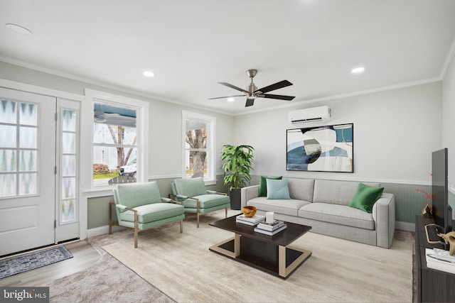 living room with ceiling fan, ornamental molding, light hardwood / wood-style flooring, and a wall mounted air conditioner