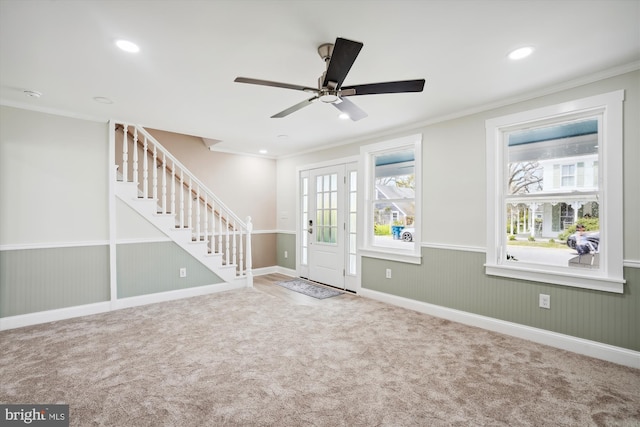 entryway with ceiling fan, carpet floors, crown molding, and a wealth of natural light