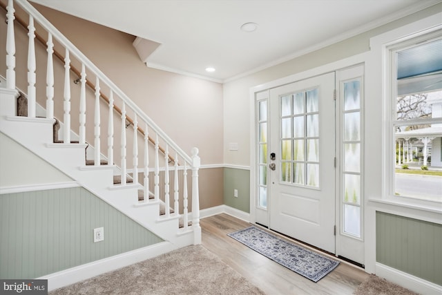 foyer with hardwood / wood-style floors and crown molding