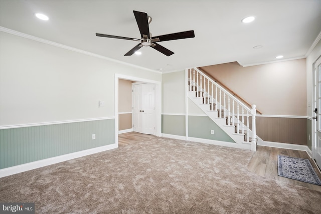 unfurnished living room with carpet flooring, ornamental molding, and ceiling fan