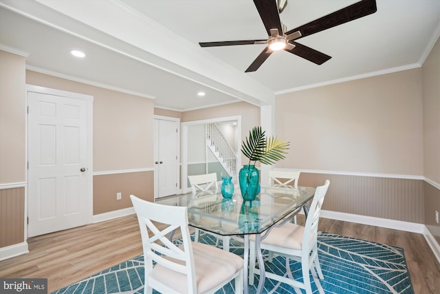 dining area featuring beamed ceiling, ceiling fan, ornamental molding, and wood-type flooring