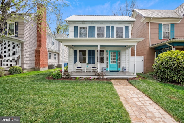 view of front of property with a front yard, central AC, and covered porch