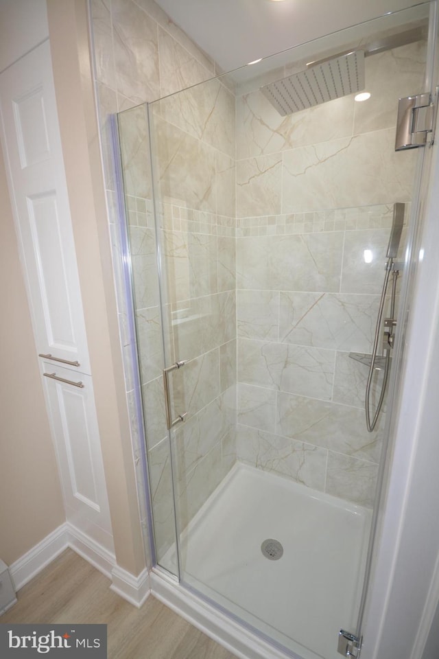 bathroom with an enclosed shower and hardwood / wood-style flooring