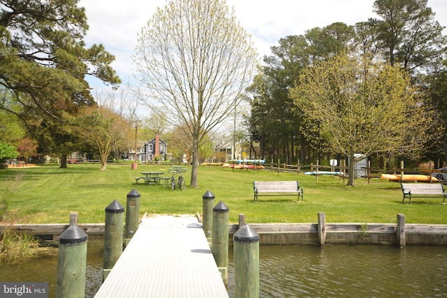 view of dock featuring a yard and a water view