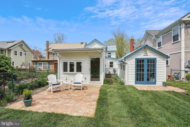 rear view of house with a lawn and a patio