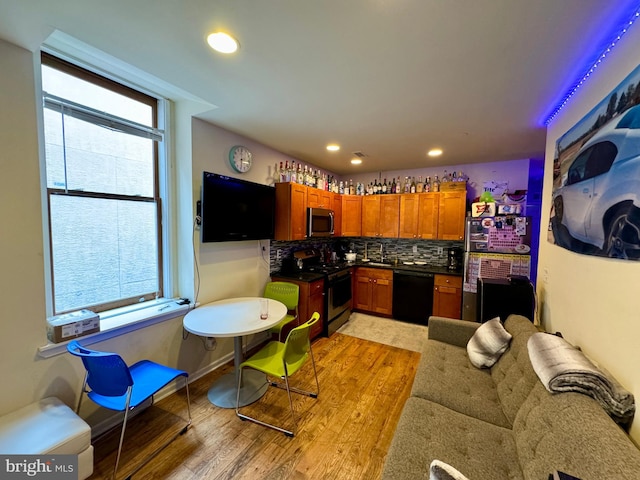 kitchen featuring backsplash, light hardwood / wood-style floors, and stainless steel appliances