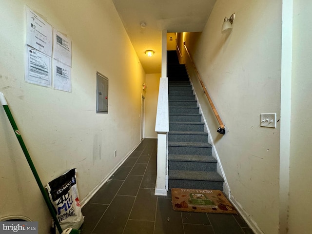 staircase with tile patterned floors and electric panel