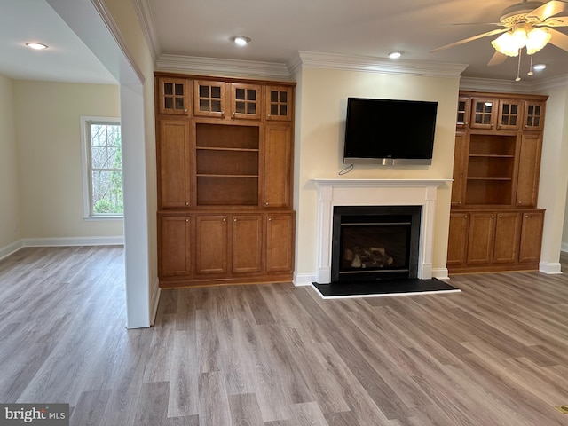 unfurnished living room featuring crown molding, ceiling fan, and light hardwood / wood-style flooring