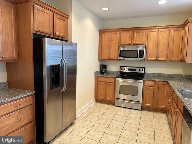 kitchen with light tile flooring, appliances with stainless steel finishes, and sink