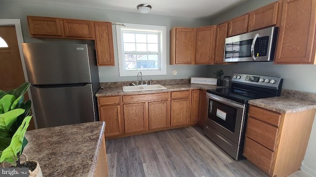 kitchen with light hardwood / wood-style floors, sink, and stainless steel appliances