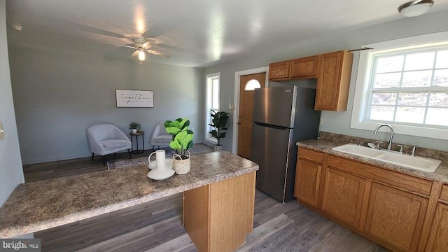 kitchen featuring stainless steel fridge, hardwood / wood-style floors, ceiling fan, and sink