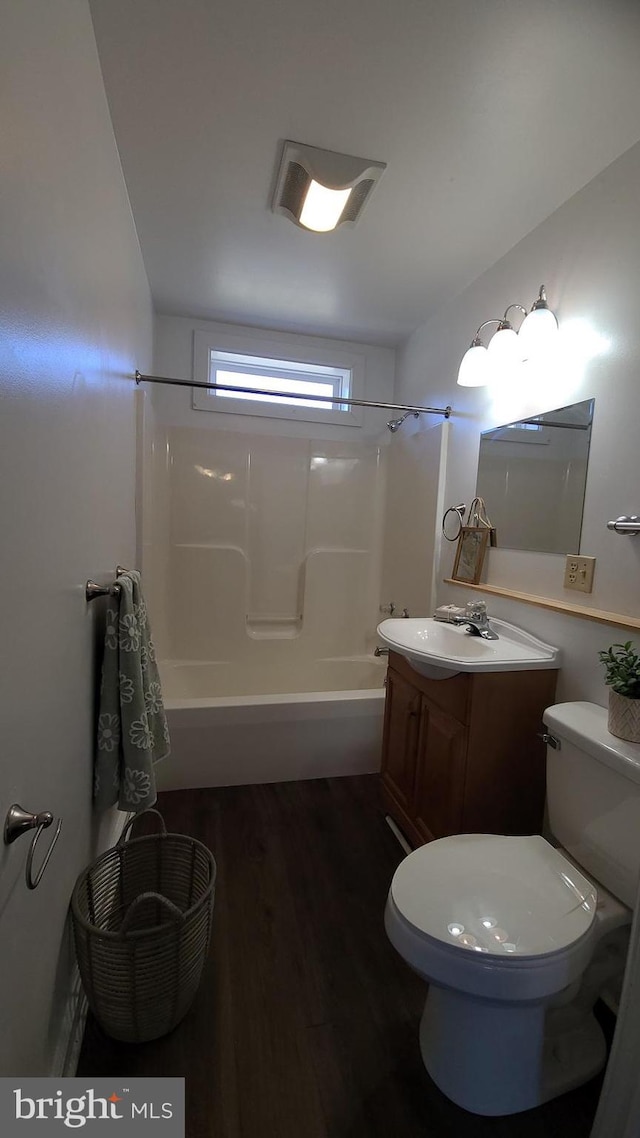 full bathroom featuring bathing tub / shower combination, toilet, vanity, and wood-type flooring